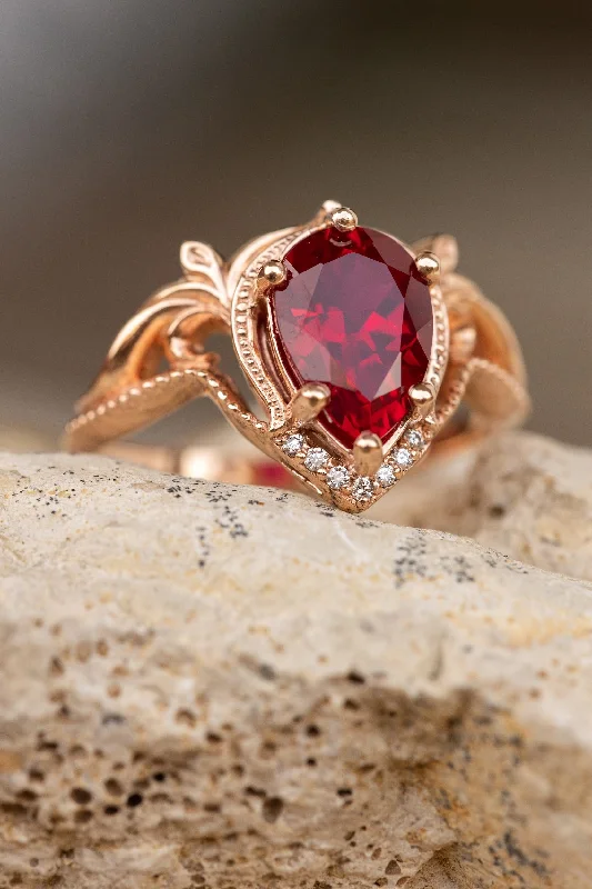 Men's Diamond Engagement Rings with Platinum Band and Halo Setting for a Luxury ProposalREADY TO SHIP: Lida ring in 14K rose gold, lab ruby pear cut 10x7mm, accent moissanites, AVAILABLE RING SIZES: 5.5 - 8.5 US